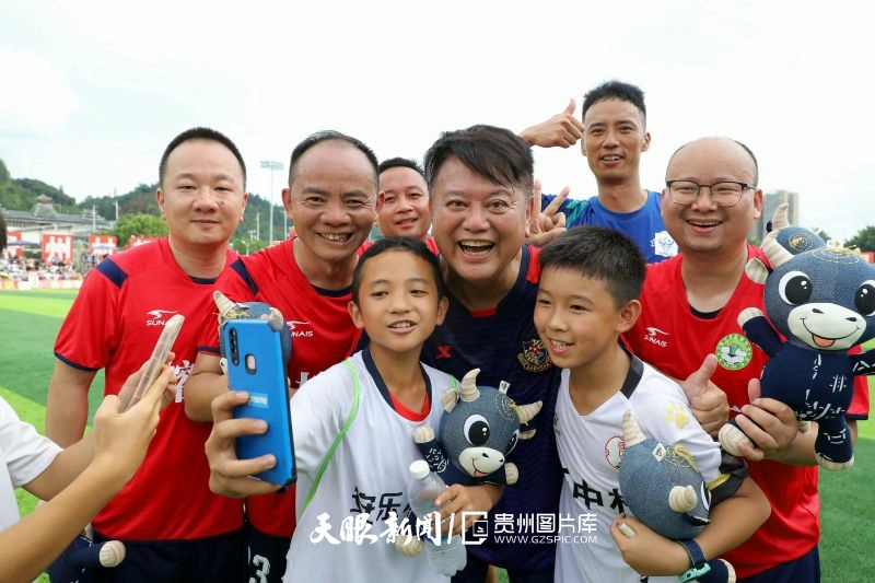 dD0xNzYzNjg4MDU5X3I9ZjBhZjE2NWZfdz04MDBfcT0xMDBfZT1qcGc=.webp 图12:2023年8月13日,在贵州省黔东南州苗族侗族自治州榕江县城北新区足球场,榕江村民队球员与香港明星足球队陈百祥合影纪念。.jpg
