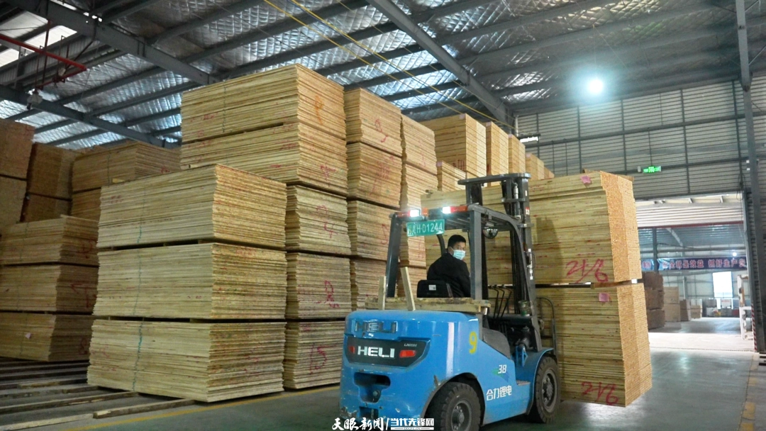 贵州旭昇木业有限公司车间内，工人正在用叉车码放板材.png
